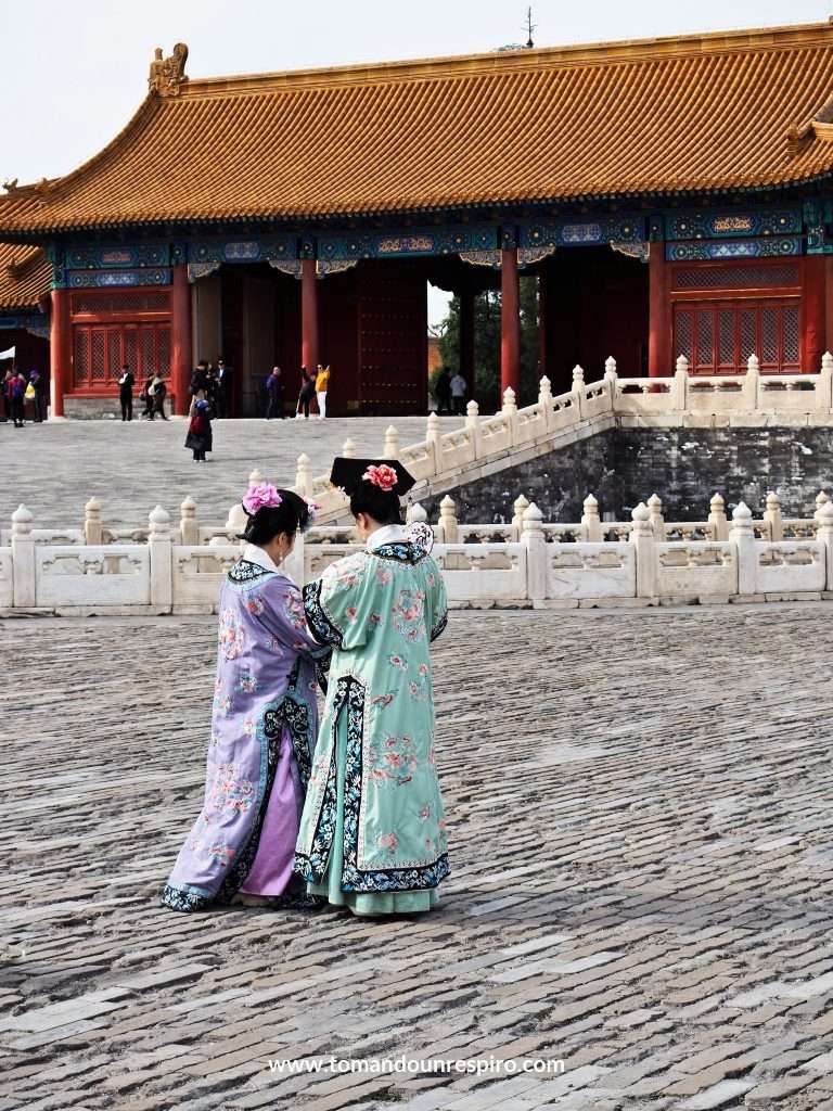 Dos mujeres con trajes tradicionales en la explanada de la Ciudad Prohibida