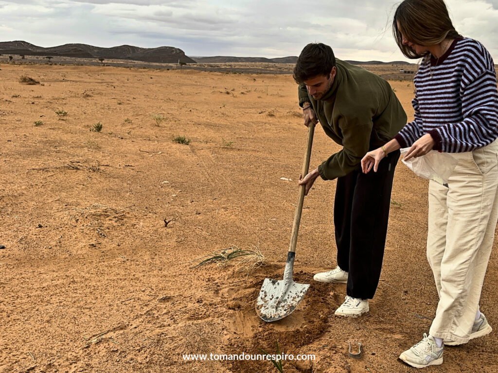 Chris y Andrea cavando en la arena del desierto con una pala
