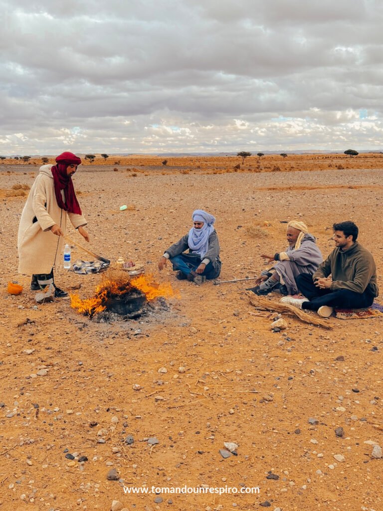 Nómadas preparando té junto a un fuego en el desierto
